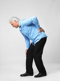 Photo of Full length portrait of senior man having knee problems on grey background