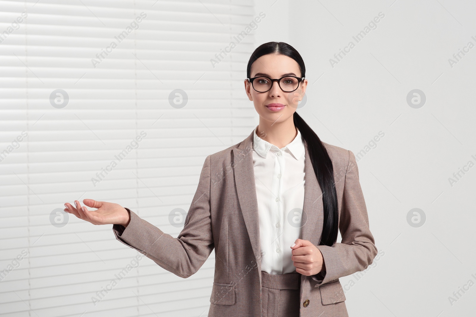 Photo of Beautiful real estate agent in nice suit indoors