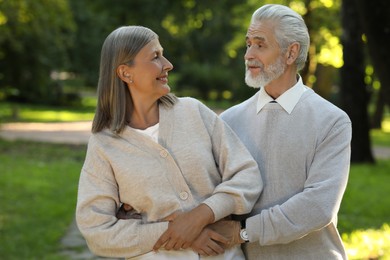 Photo of Affectionate senior couple spending time together in park. Romantic date