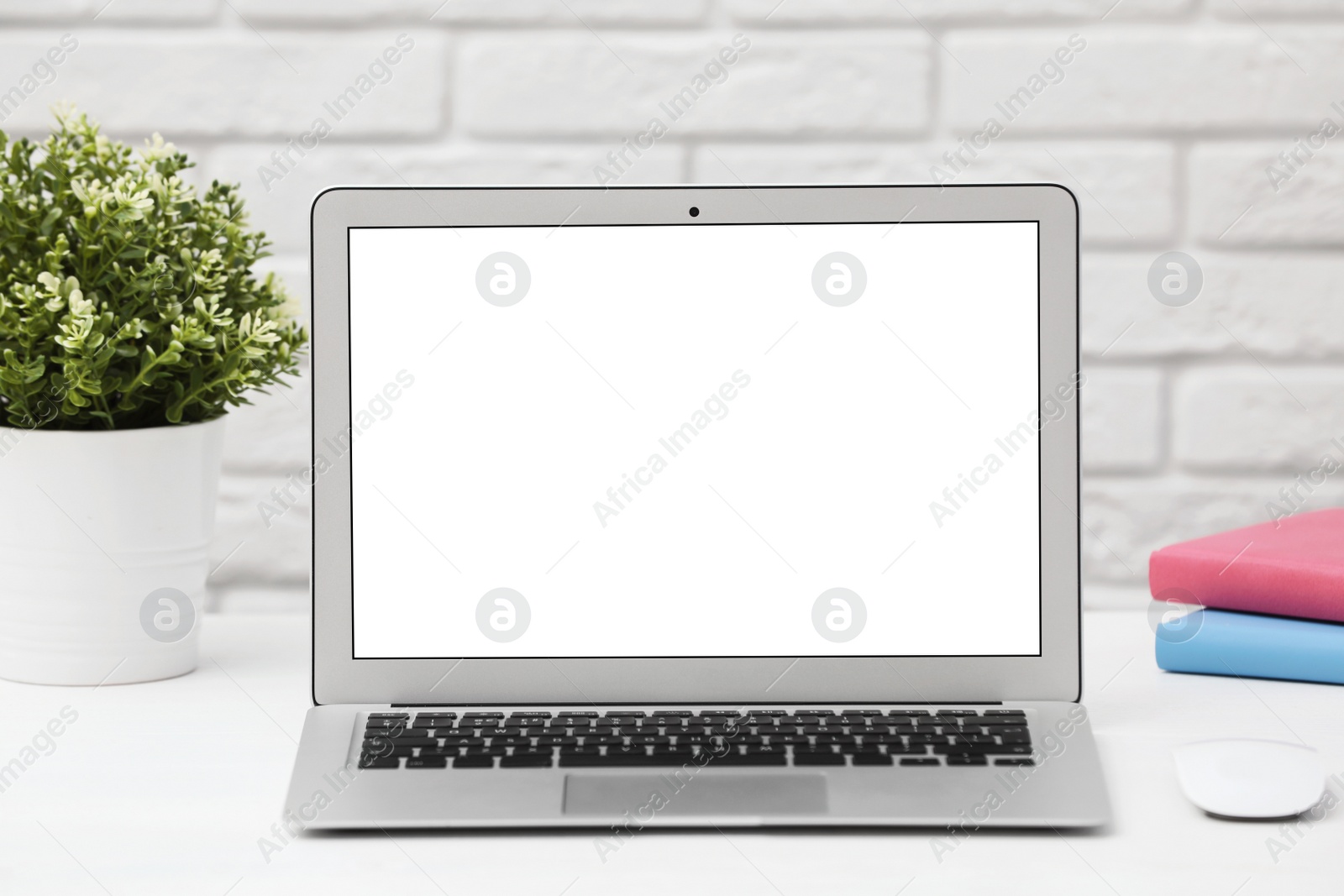 Photo of Laptop with blank screen on table indoors. Space for text