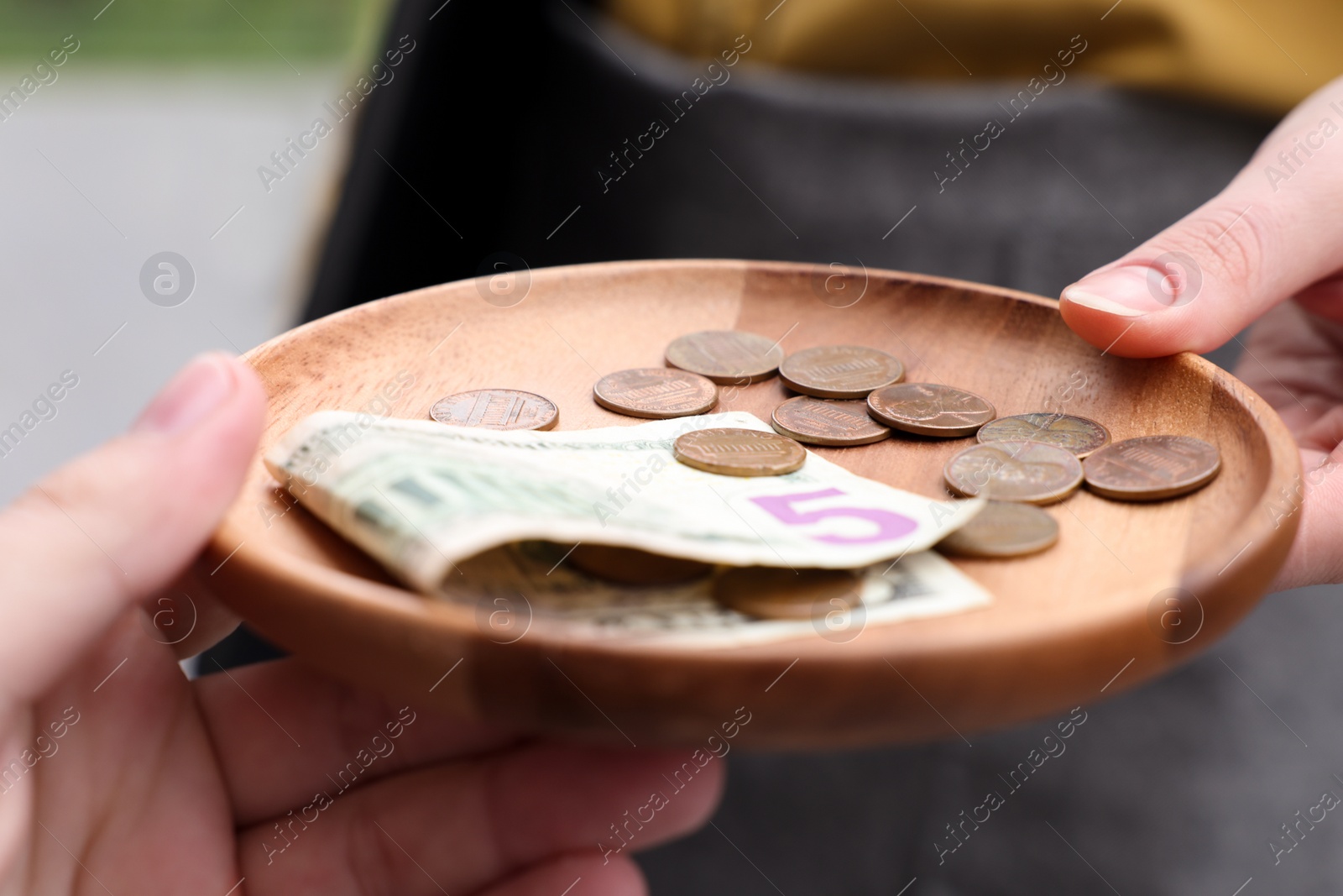 Photo of Client giving tips to waitress in outdoor cafe, closeup