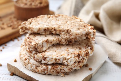 Photo of Stack of crunchy buckwheat cakes on wooden table, closeup