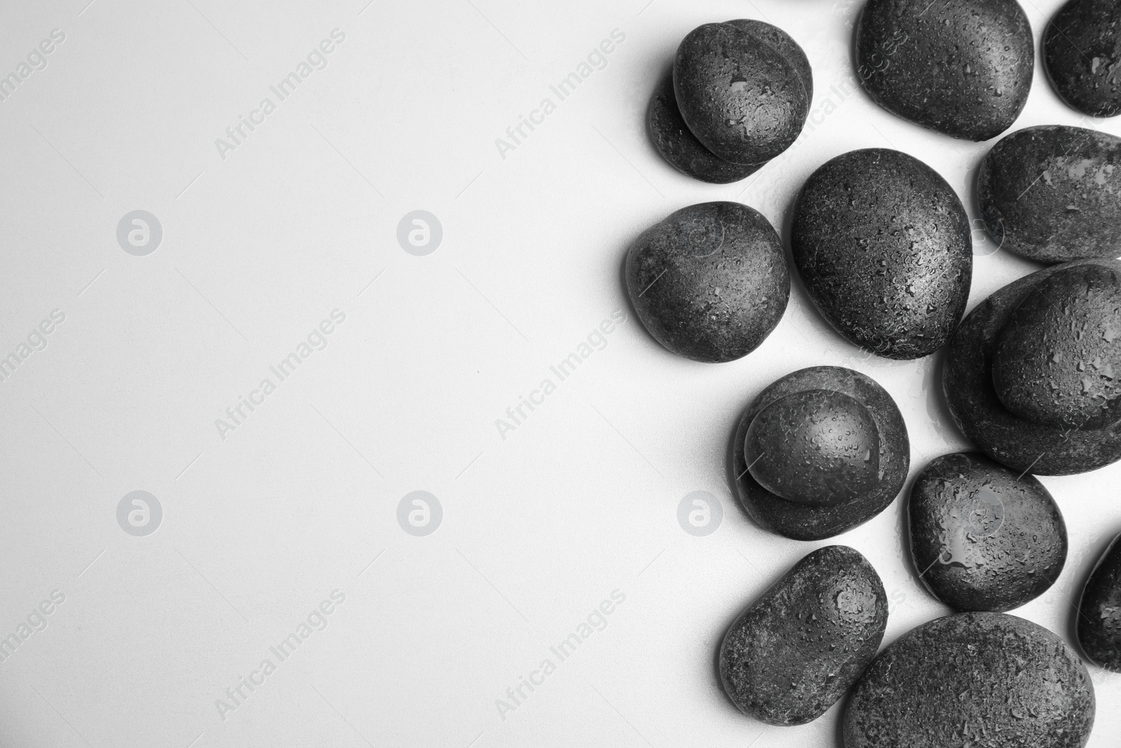 Photo of Wet zen stones on white background, top view with space for text