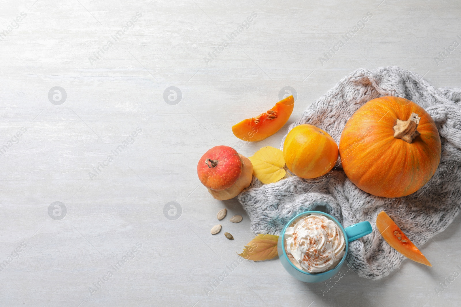 Photo of Flat lay composition with cup of pumpkin spice latte, autumn decor and space for text on light table