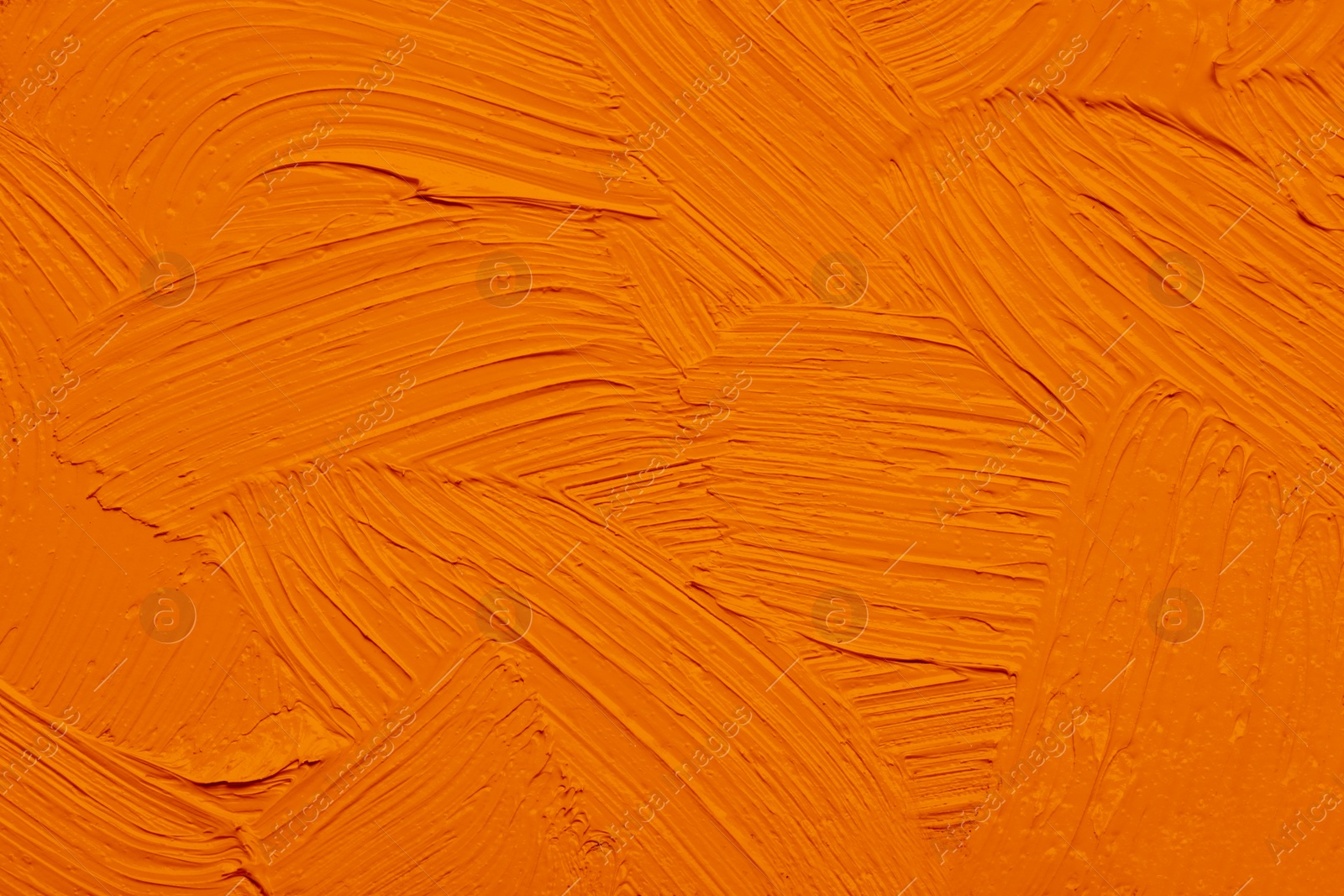 Image of Strokes of orange oil paint as background, closeup