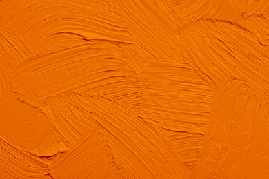 Image of Strokes of orange oil paint as background, closeup