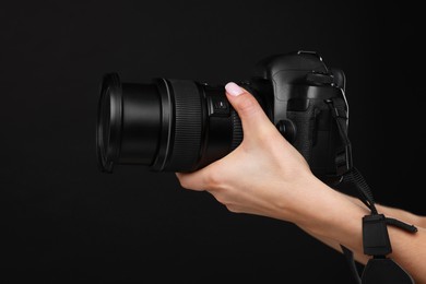 Photo of Photographer with camera on black background, closeup