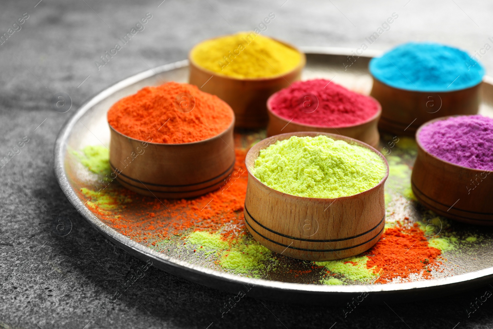 Photo of Colorful powder dyes on grey background, closeup. Holi festival