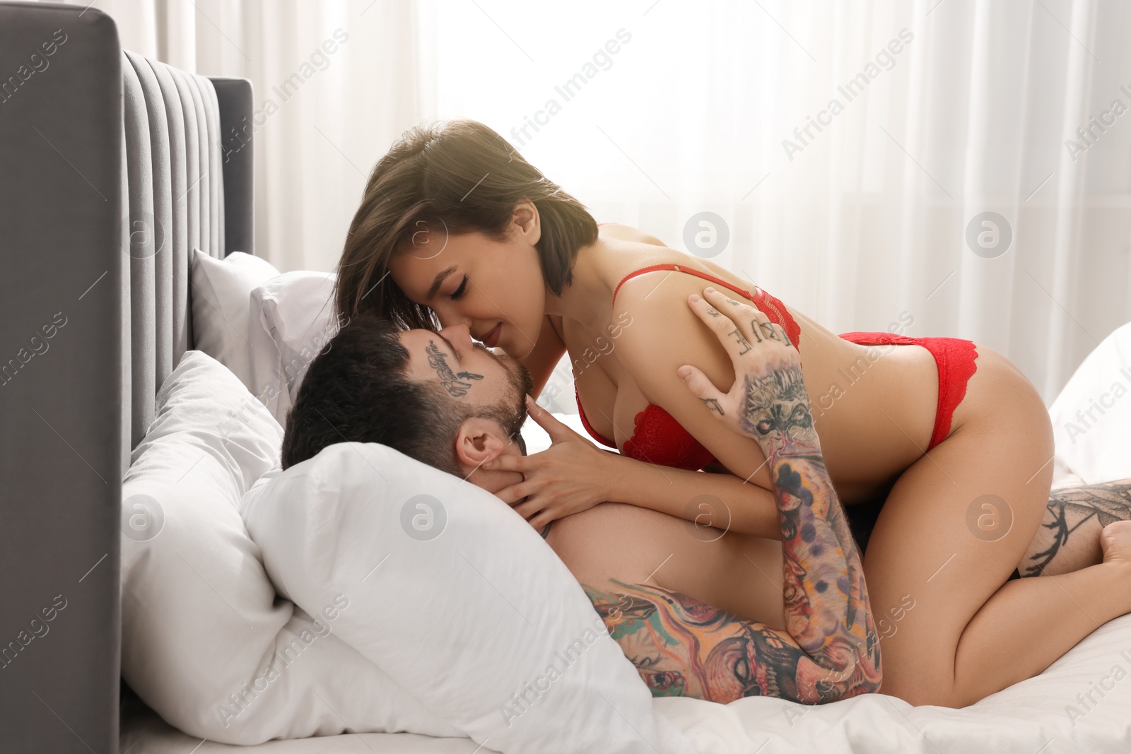 Photo of Passionate couple having sex on bed at home