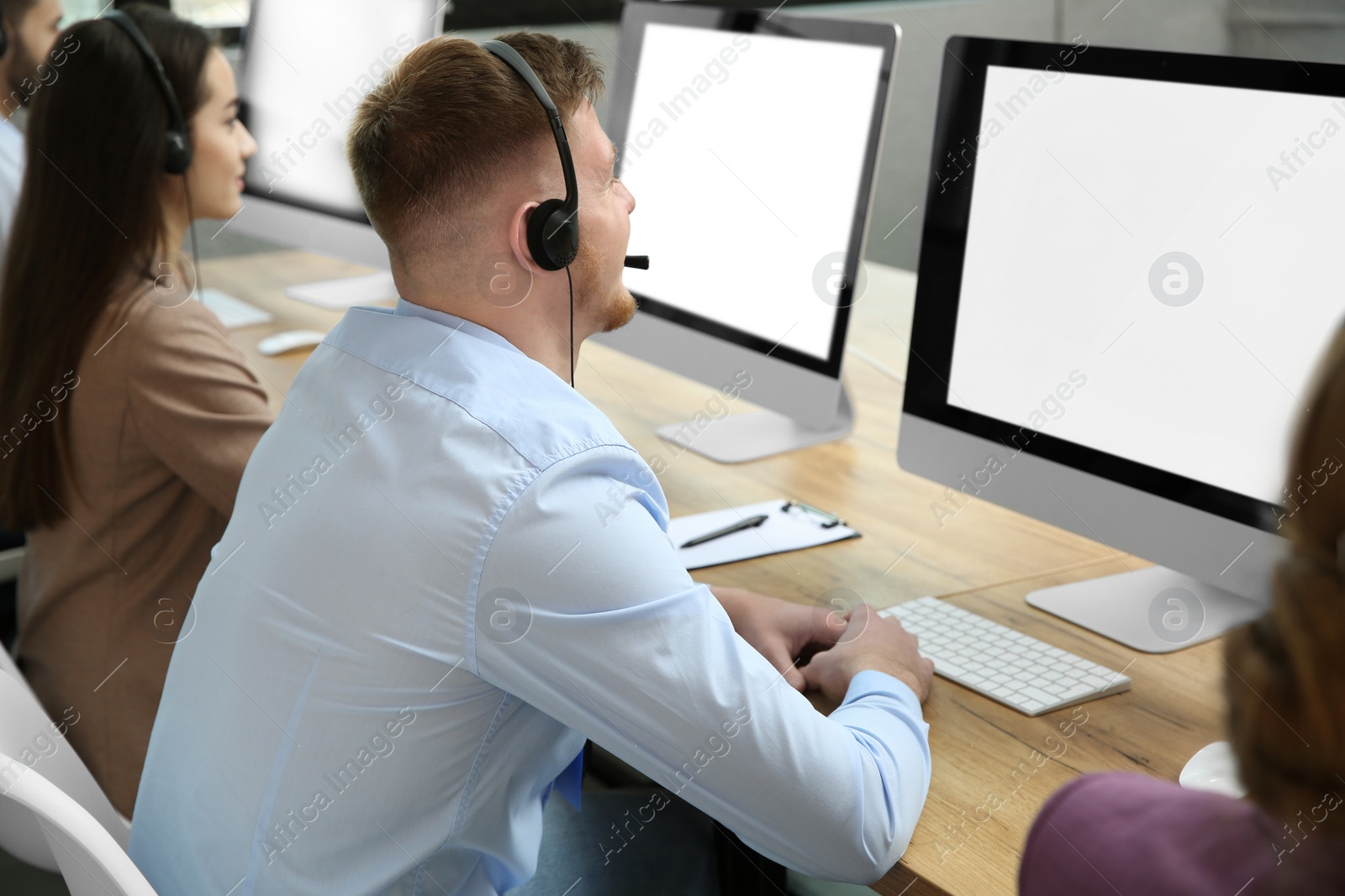 Photo of Technical support operator working with colleagues in office