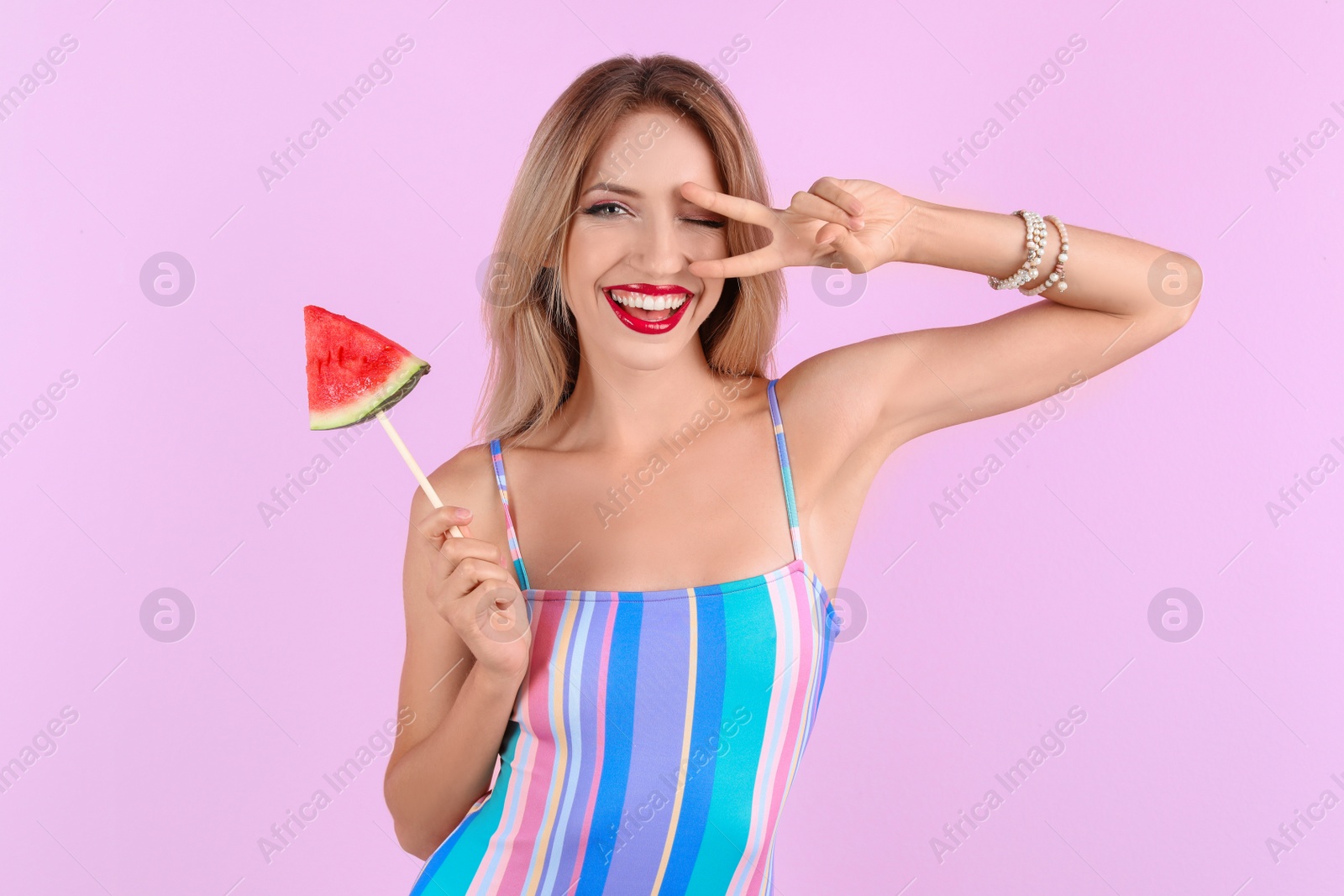 Photo of Pretty young woman with juicy watermelon on color background