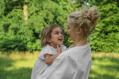 Photo of Beautiful mother with her cute daughter spending time together outdoors
