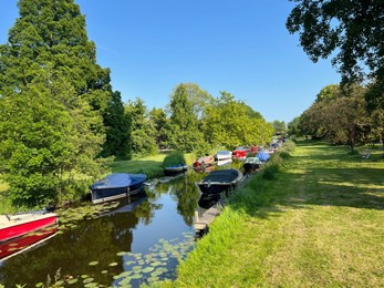 Canal with moored boats outdoors on sunny day