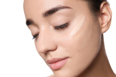 Photo of Young woman with different shades of skin foundation on her face against white background