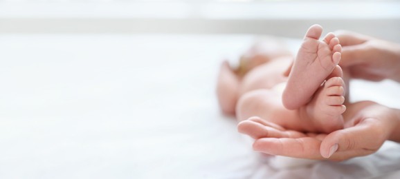 Image of Mother and her newborn baby on bed, closeup view with space for text. Banner design