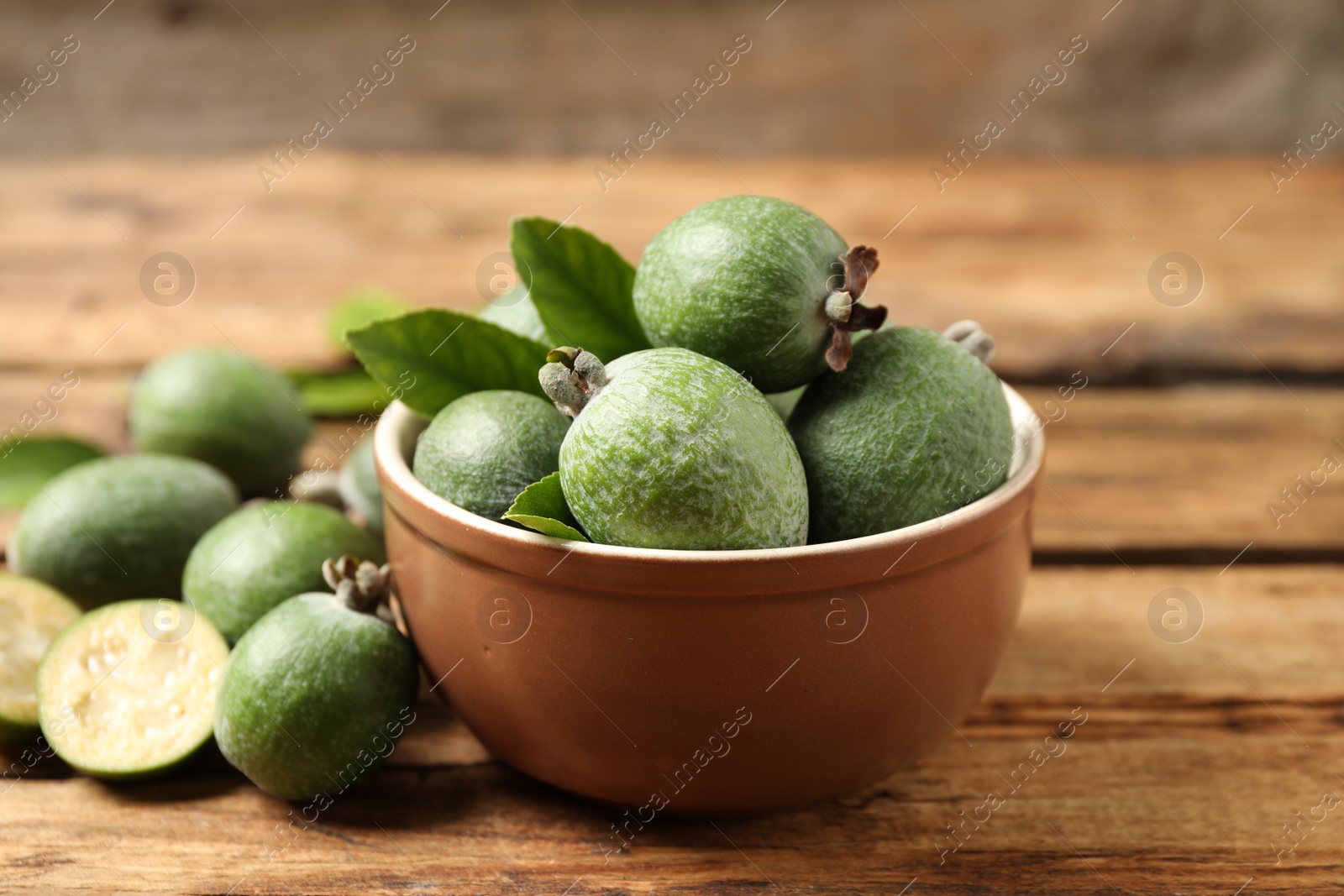 Photo of Fresh green feijoa fruits on wooden table, closeup