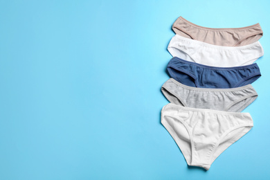 Photo of Women's underwear on light blue background, flat lay. Space for text