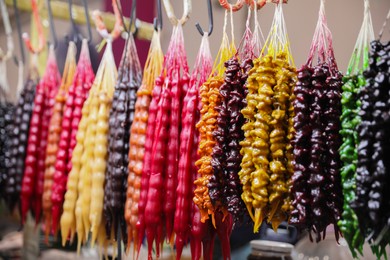 Photo of Bunches of different delicious churchkhelas at market