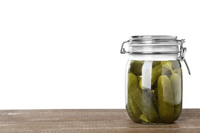 Photo of Jar with pickled cucumbers on wooden table against white background. Space for text