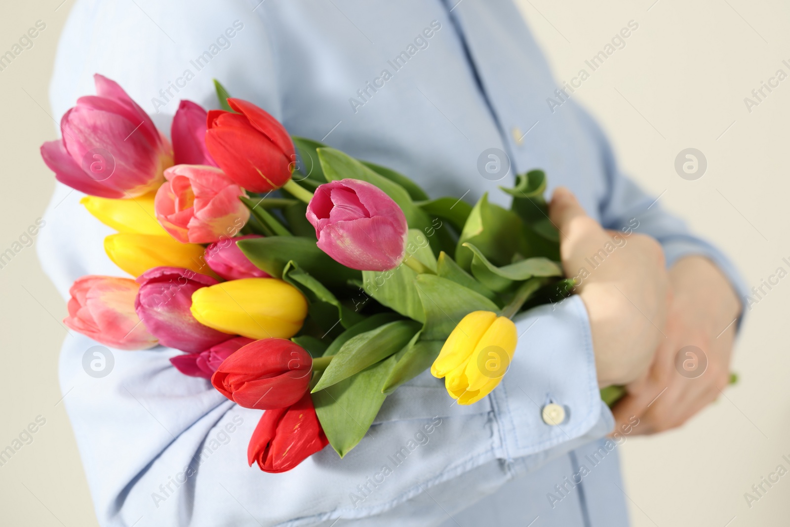 Photo of Woman holding beautiful colorful tulip flowers on white background, closeup