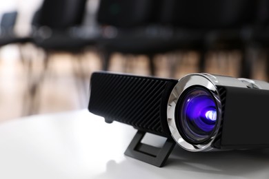 Photo of Modern video projector on table in conference room