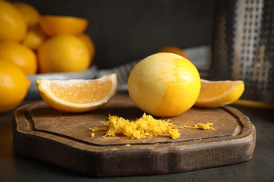 Photo of Lemon zest and fresh fruits on grey table, closeup