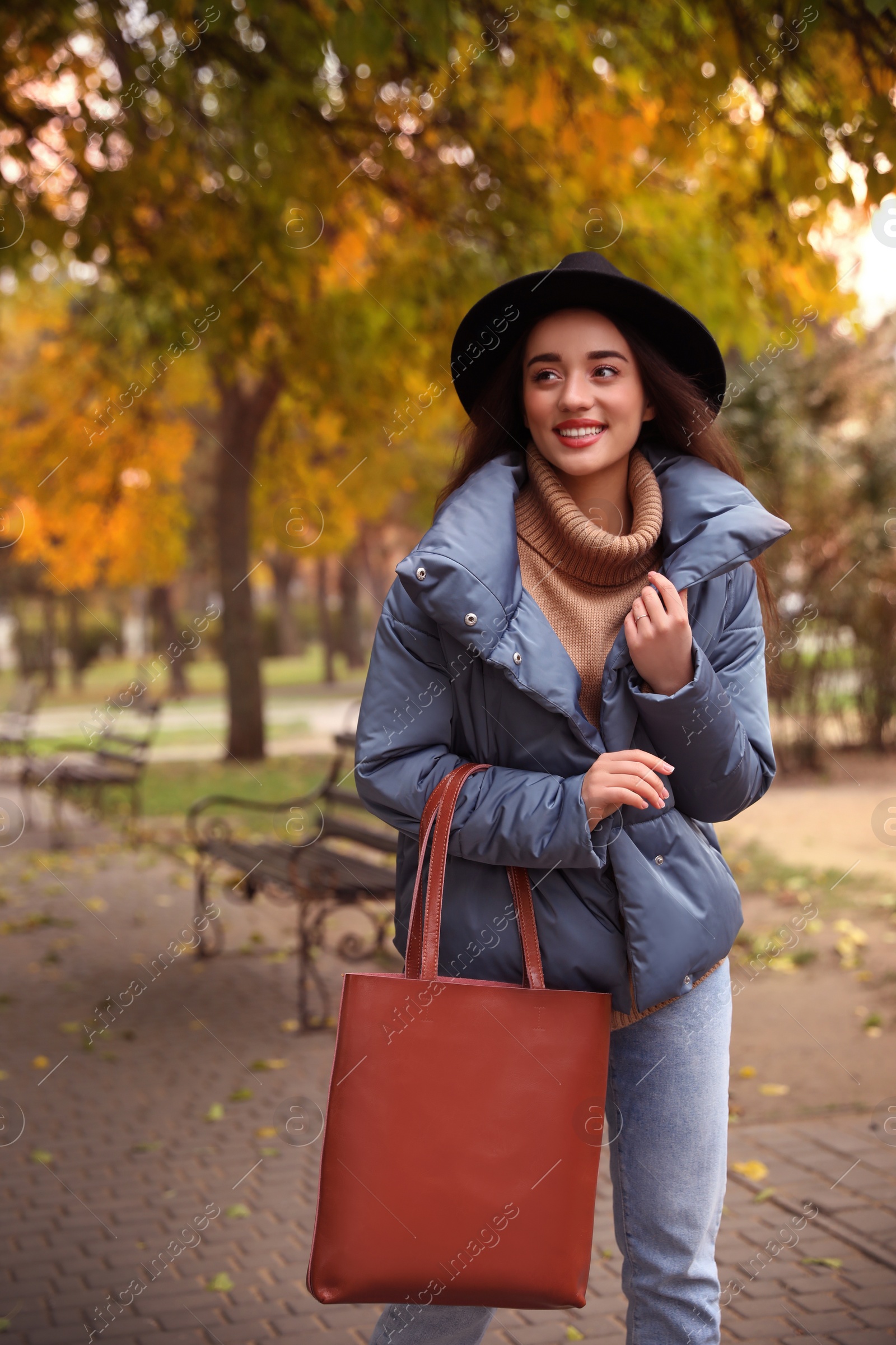 Photo of Young woman wearing stylish clothes in autumn park