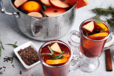 Photo of Tasty mulled wine with spices on grey marble table