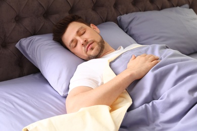 Photo of Handsome man sleeping on pillow at home. Bedtime