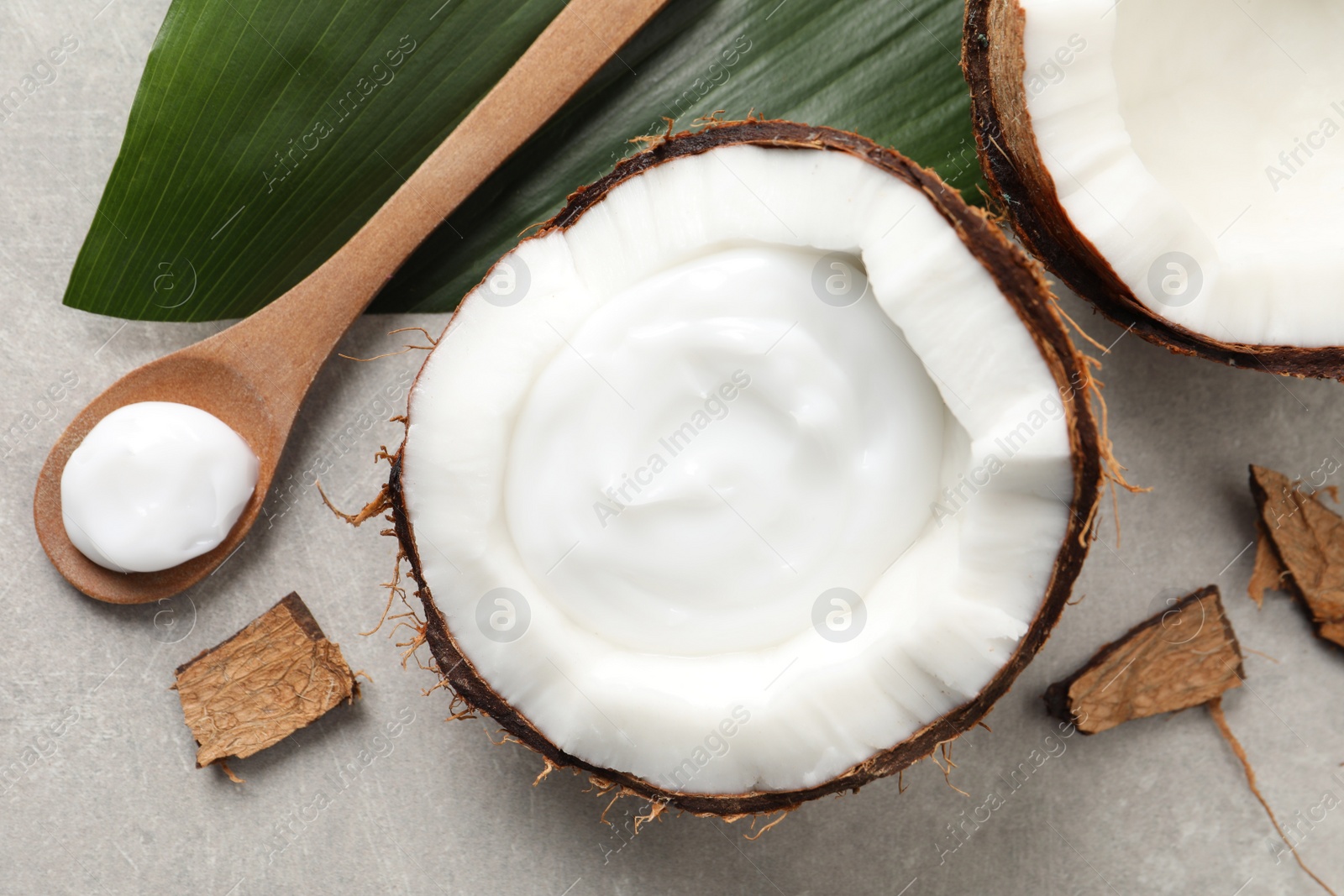 Photo of Ripe coconut and cream on light grey table, flat lay