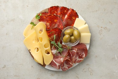 Serving board with delicious cured ham, cheese, sausage and olives on light table, top view