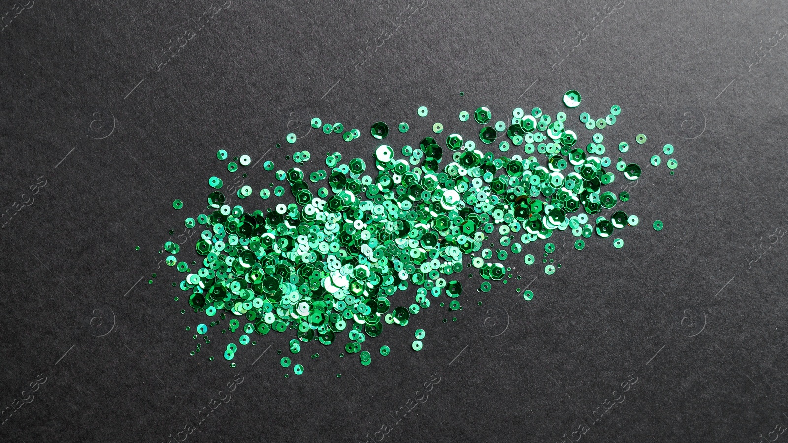 Photo of Pile of beautiful sequins on black background, flat lay