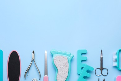 Photo of Set of pedicure tools on light blue background, flat lay. Space for text