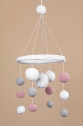 Cute baby crib mobile on beige background