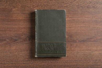 Photo of Old hardcover book on wooden table, top view