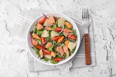 Delicious pomelo salad with tomatoes and mussels served on white textured table, flat lay