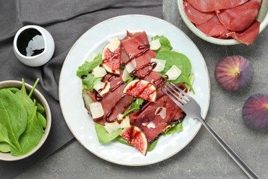 Flat lay composition with delicious bresaola salad on grey textured table