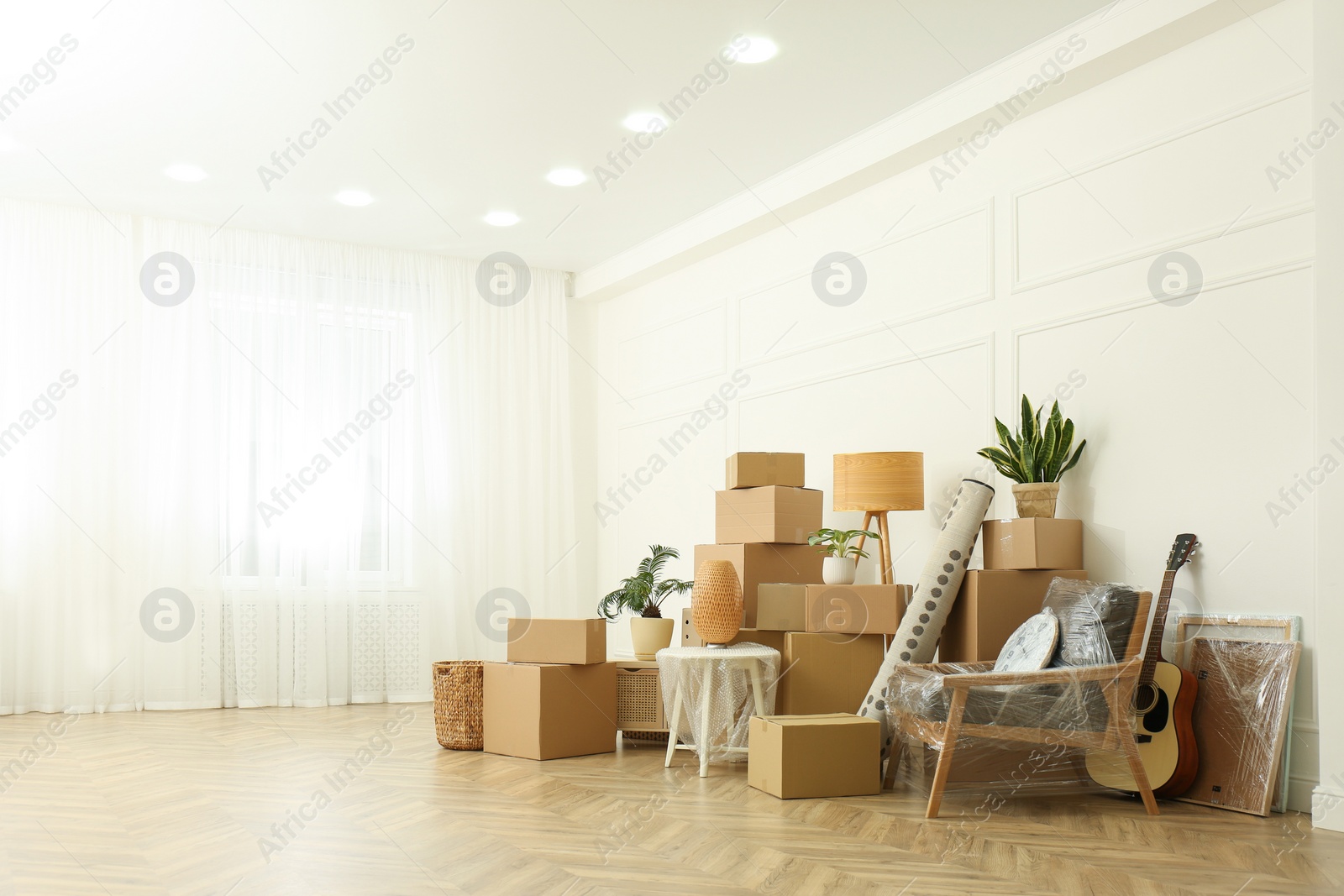 Photo of Cardboard boxes and household stuff indoors, space for text. Moving day