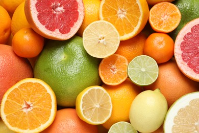 Photo of Different ripe citrus fruits as background, top view