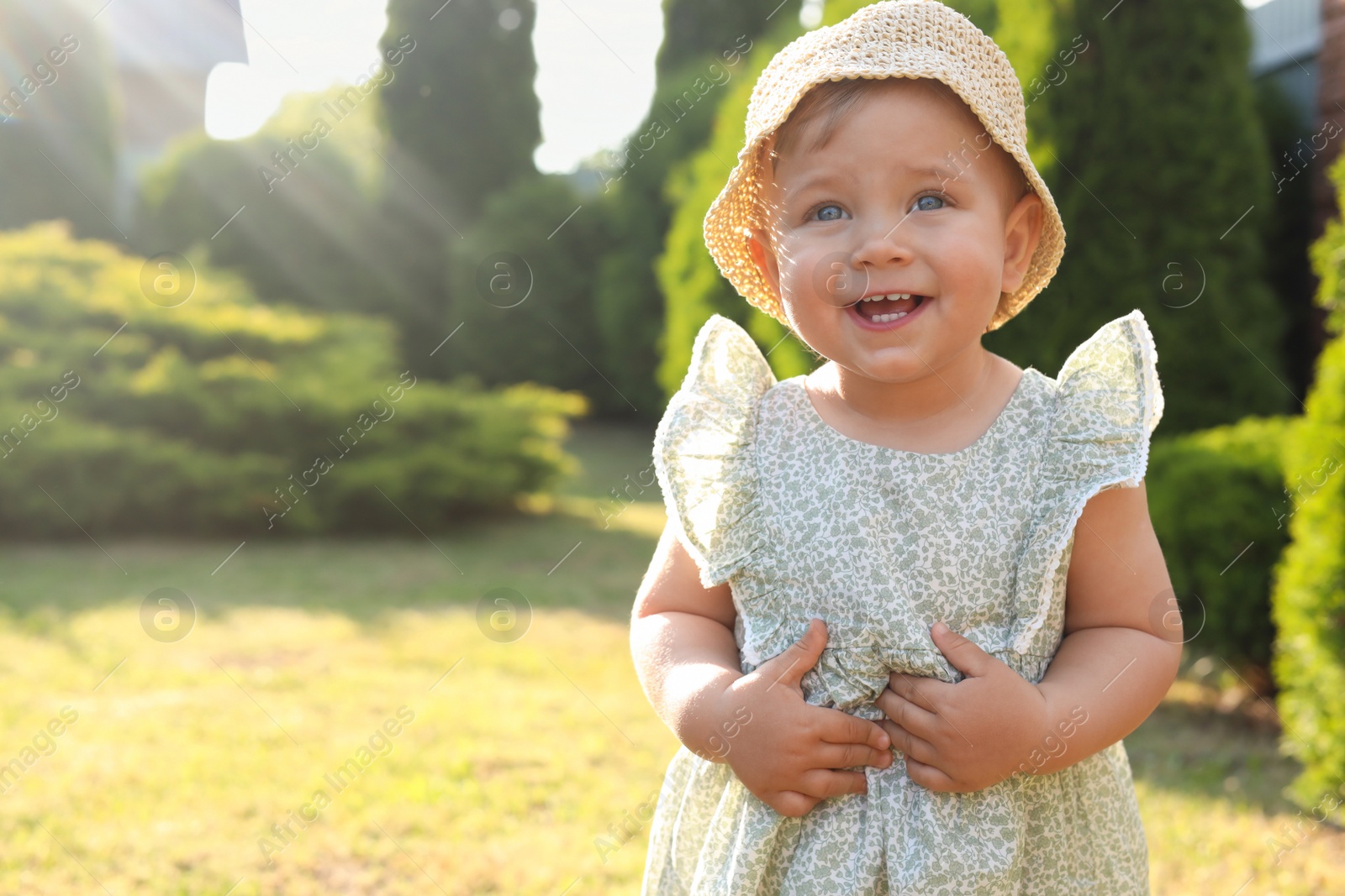Photo of Cute little girl wearing stylish clothes outdoors on sunny day. Space for text