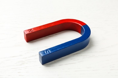 Photo of Red and blue horseshoe magnet on wooden background