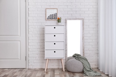 Modern room interior with large mirror and cabinet