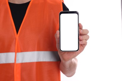 Male industrial engineer in uniform with phone on white background, closeup