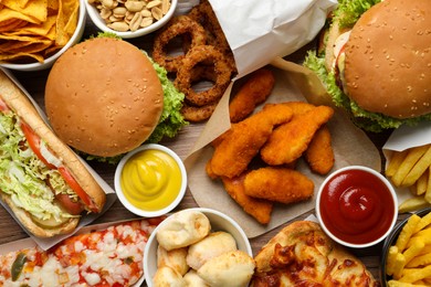 Photo of French fries, burgers and other fast food as background, top view