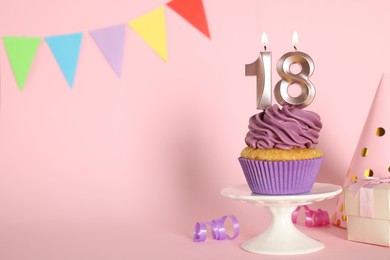 Photo of Delicious cupcake with number shaped candles on pink background, space for text. Coming of age party - 18th birthday