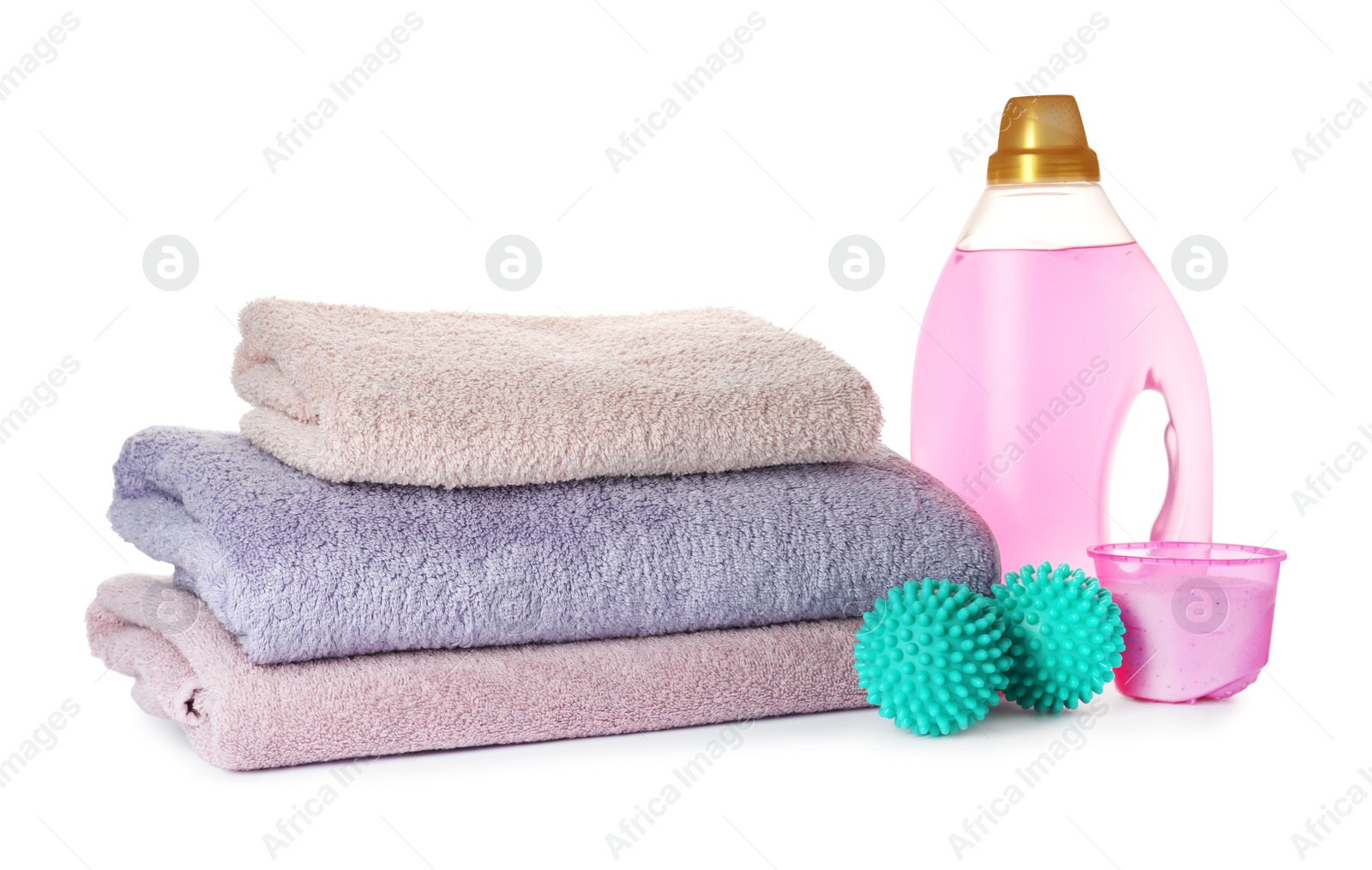 Photo of Dryer balls, detergents and stacked clean towels on white background