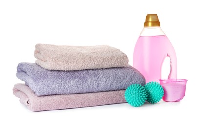 Dryer balls, detergents and stacked clean towels on white background