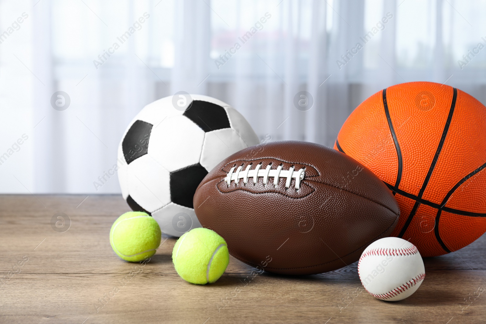 Photo of Set of different sport balls on wooden table indoors