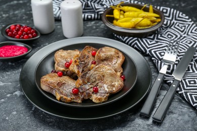 Photo of Tasty beef tongue pieces served on dark table