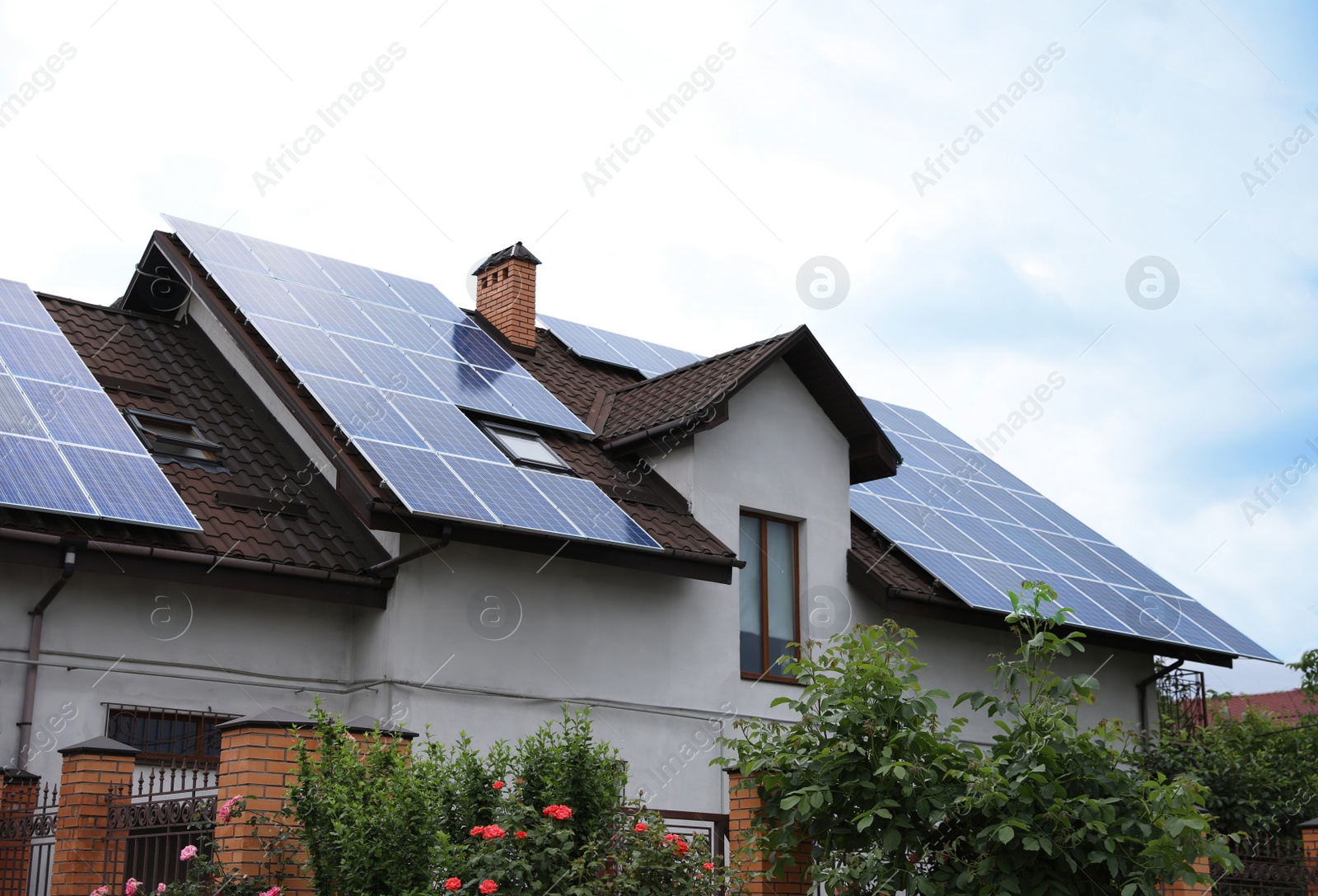 Photo of House with installed solar panels on roof. Alternative energy source